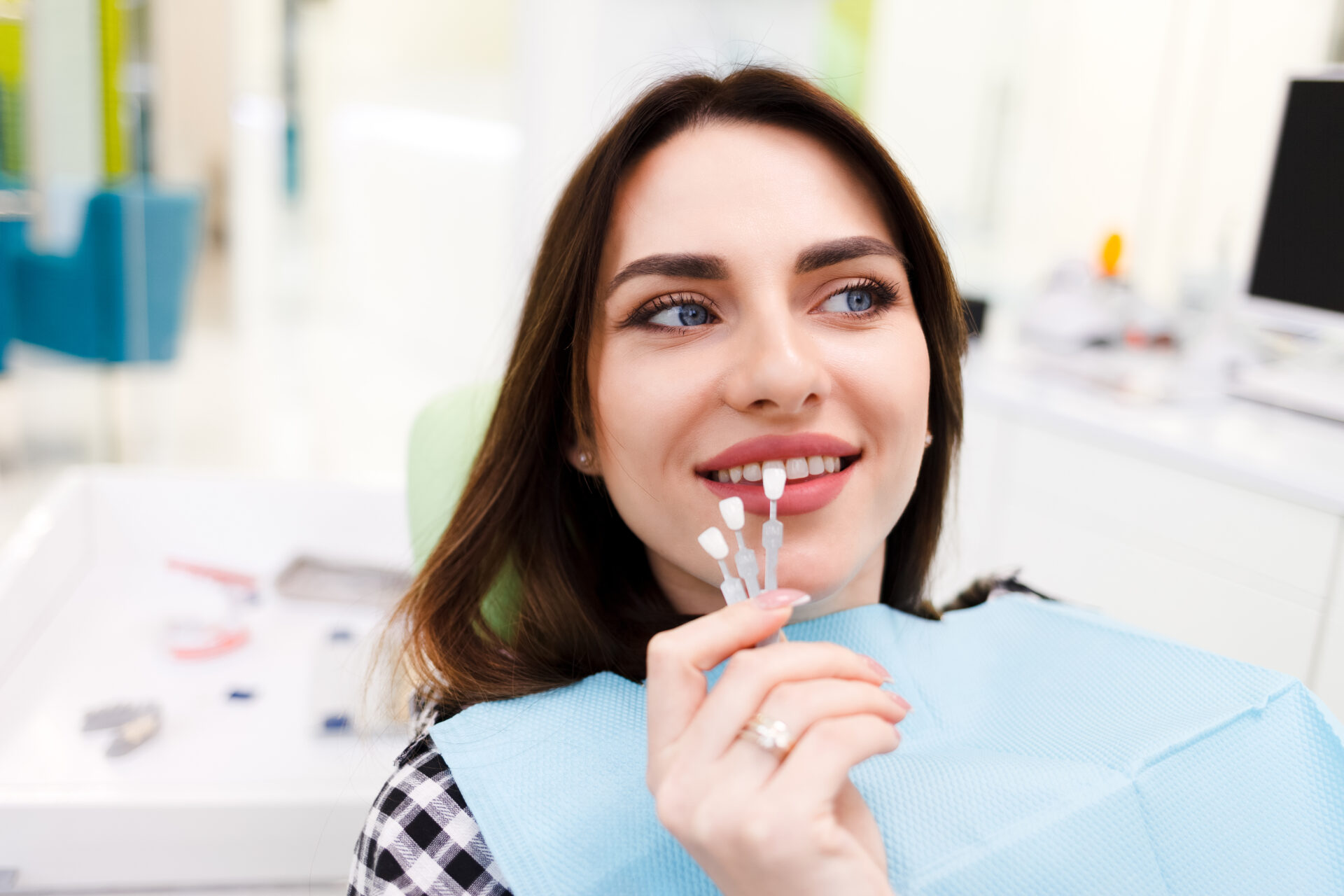 Girl Chooses Color Of Veneers At The Dentist Office Girl chooses color of veneers at the dentist office